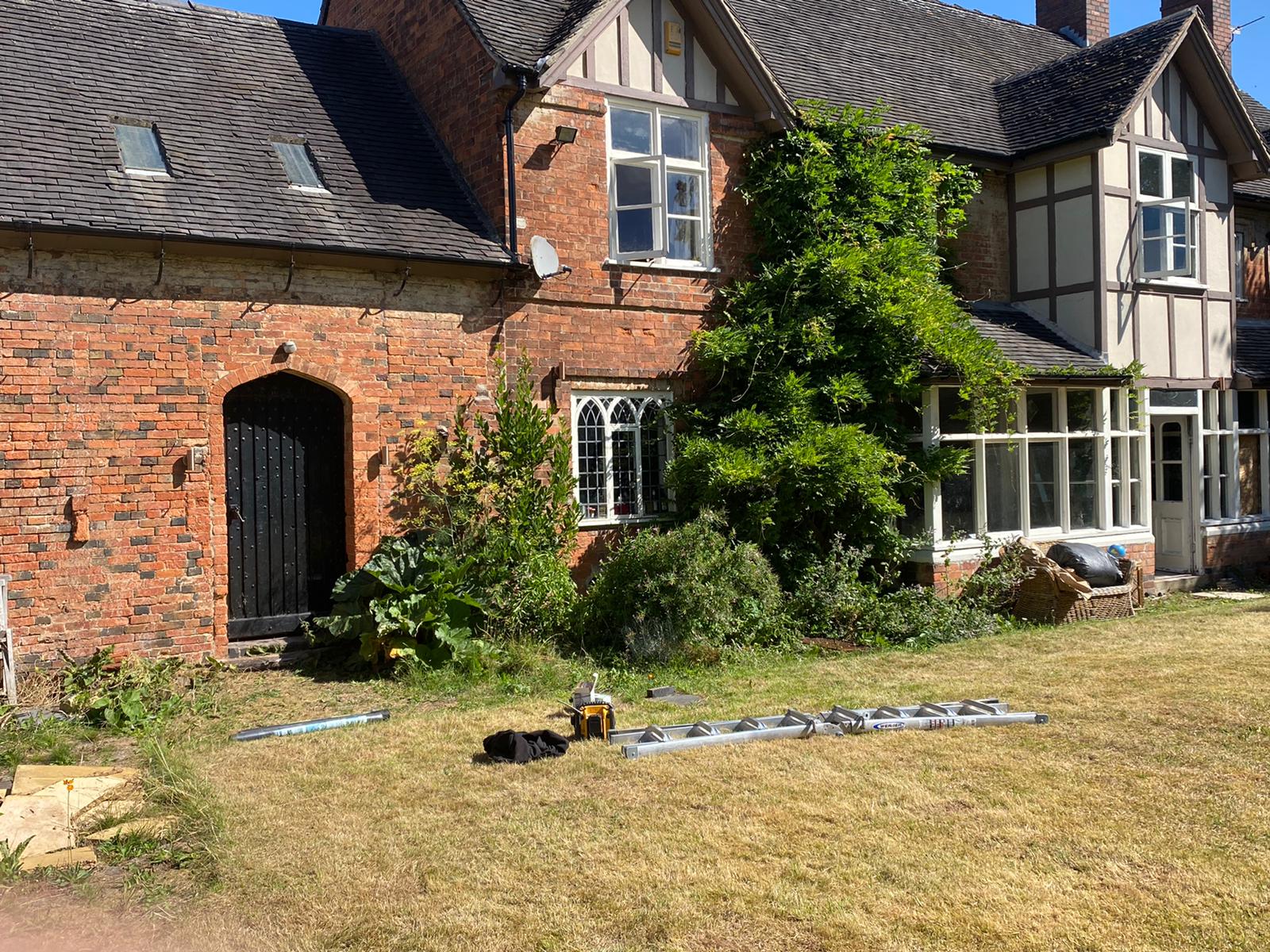 Another angle of the lights being installed on the outside of a brick house