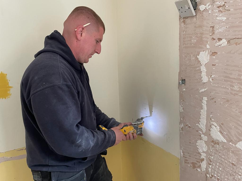 Alex is now cutting holes into the plasterboard for some new sockets!