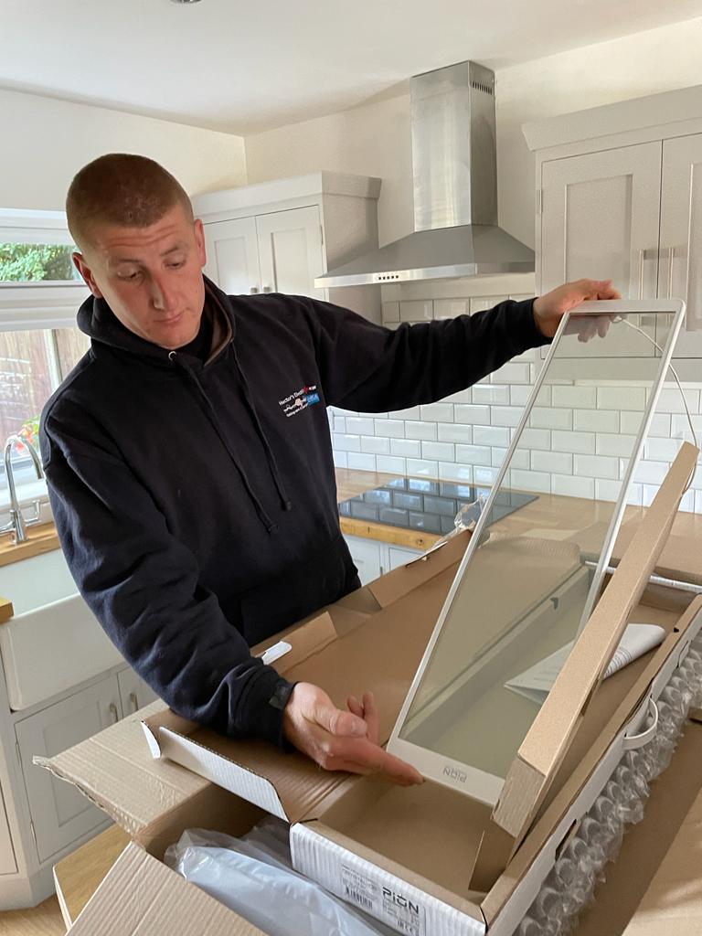 One of our workers holding the crystal glass pane out of a cardboard box, it is a infrared heater