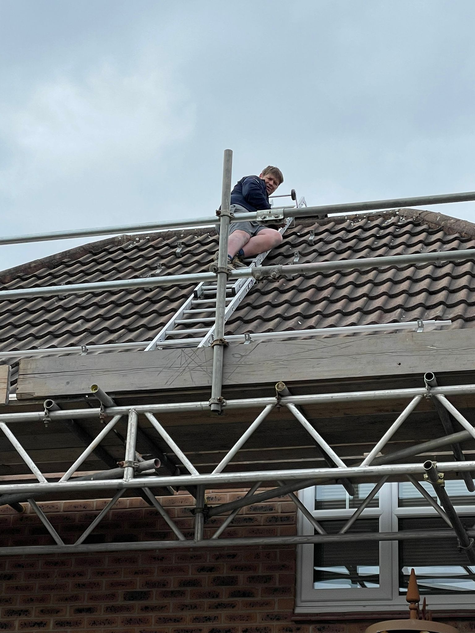 Chris is on a roof, doing some more Solar Panel installation, he is looking towards the camera