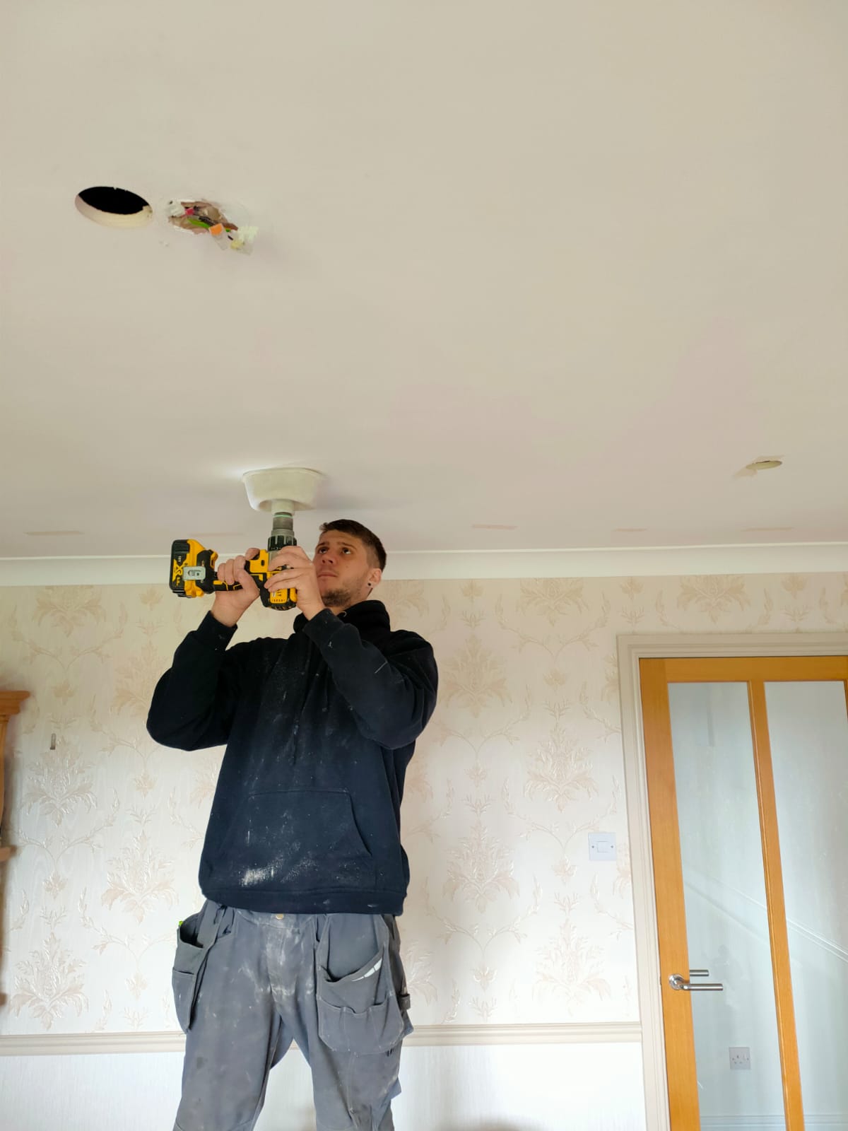 This is Jordan up by the celling drilling with a dust debris catcher, this prevents debris spilling all over the floor