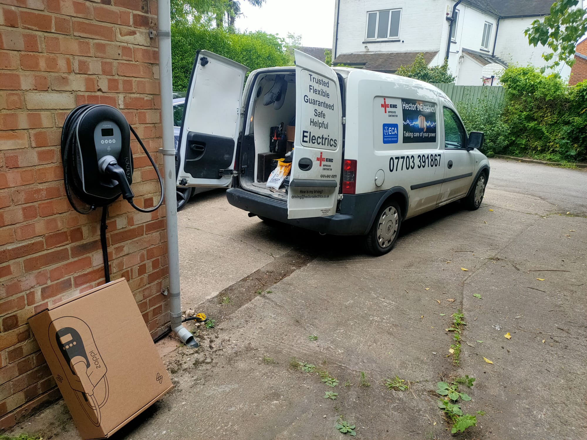 Next is an image of our van along with a EV Charger on the wall which we installed, the brand of EV charger is MyEnergi