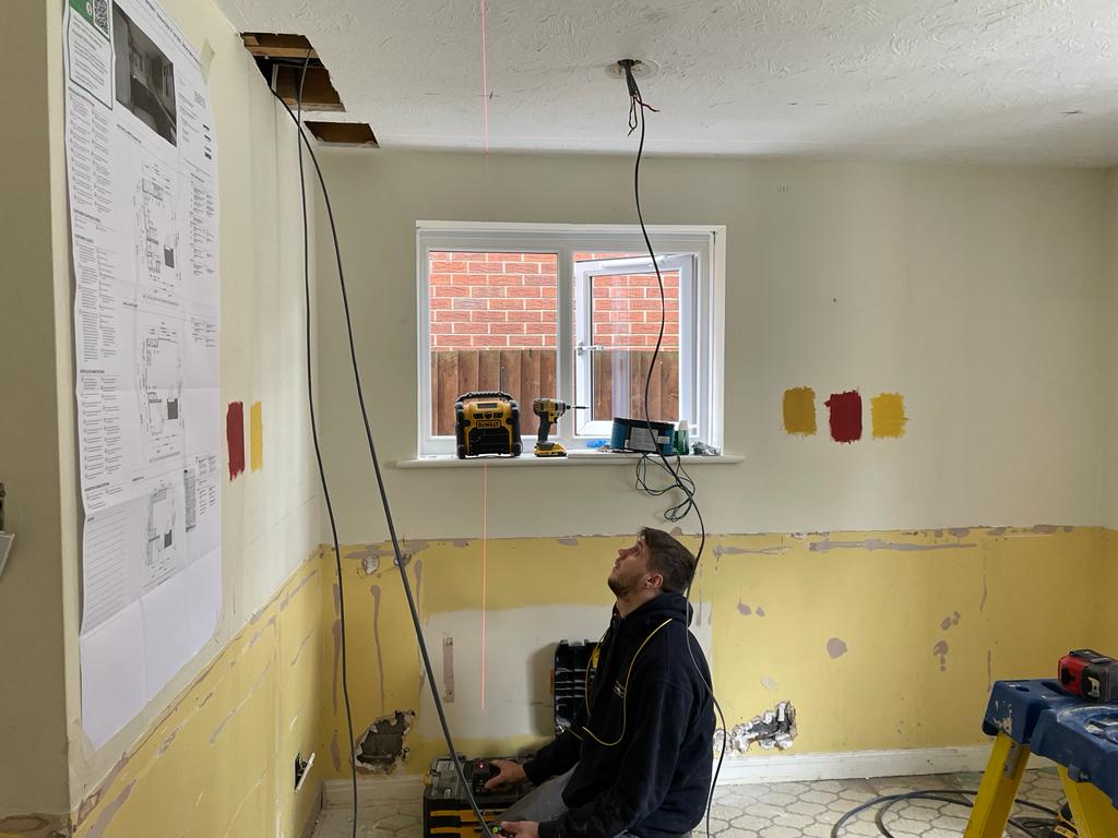 Now Jordan is using a laser measure to work out the positions for some new downlights!