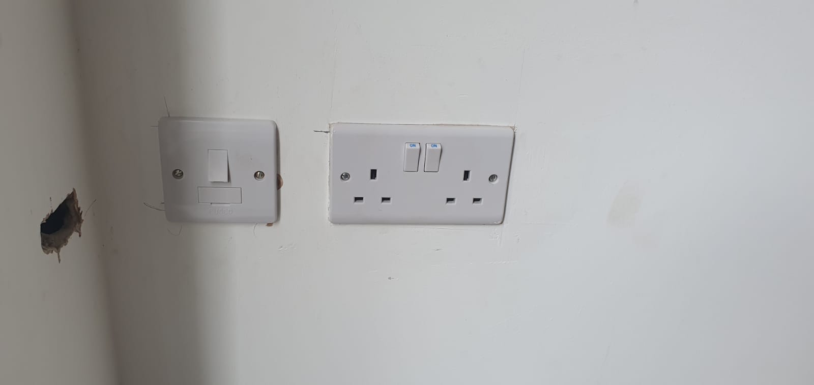 A socket is on the wall, first a single and then a double next to it
