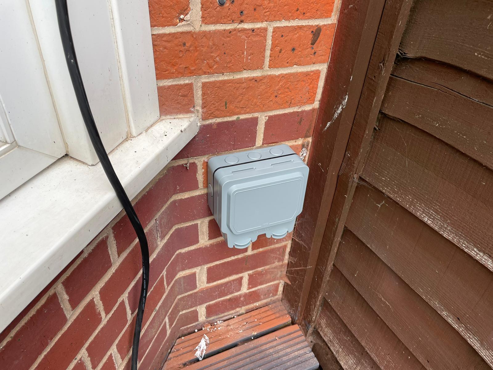 Weatherproof double socket installed in Hilton to power a 13amp hot tub, it is a double gray sized socket on a wall